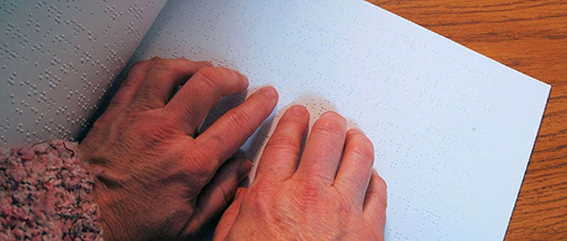 Person reading braille.